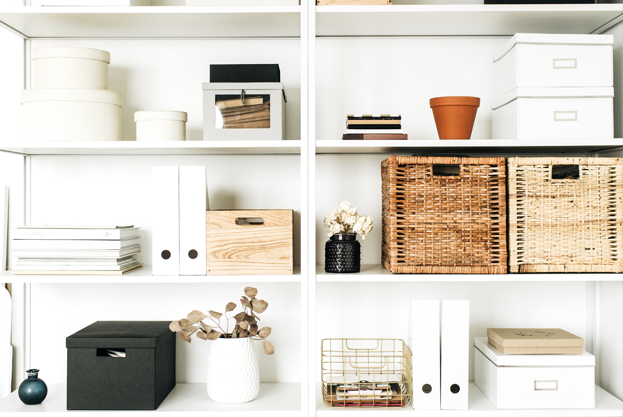 White open shelving styled with woven baskets, lidded boxes, and books